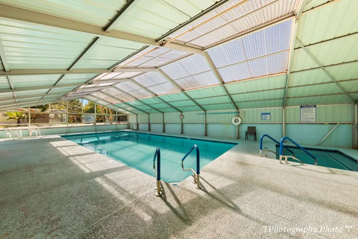 Indoor pool featuring a durable concrete surround and a two-section translucent roof