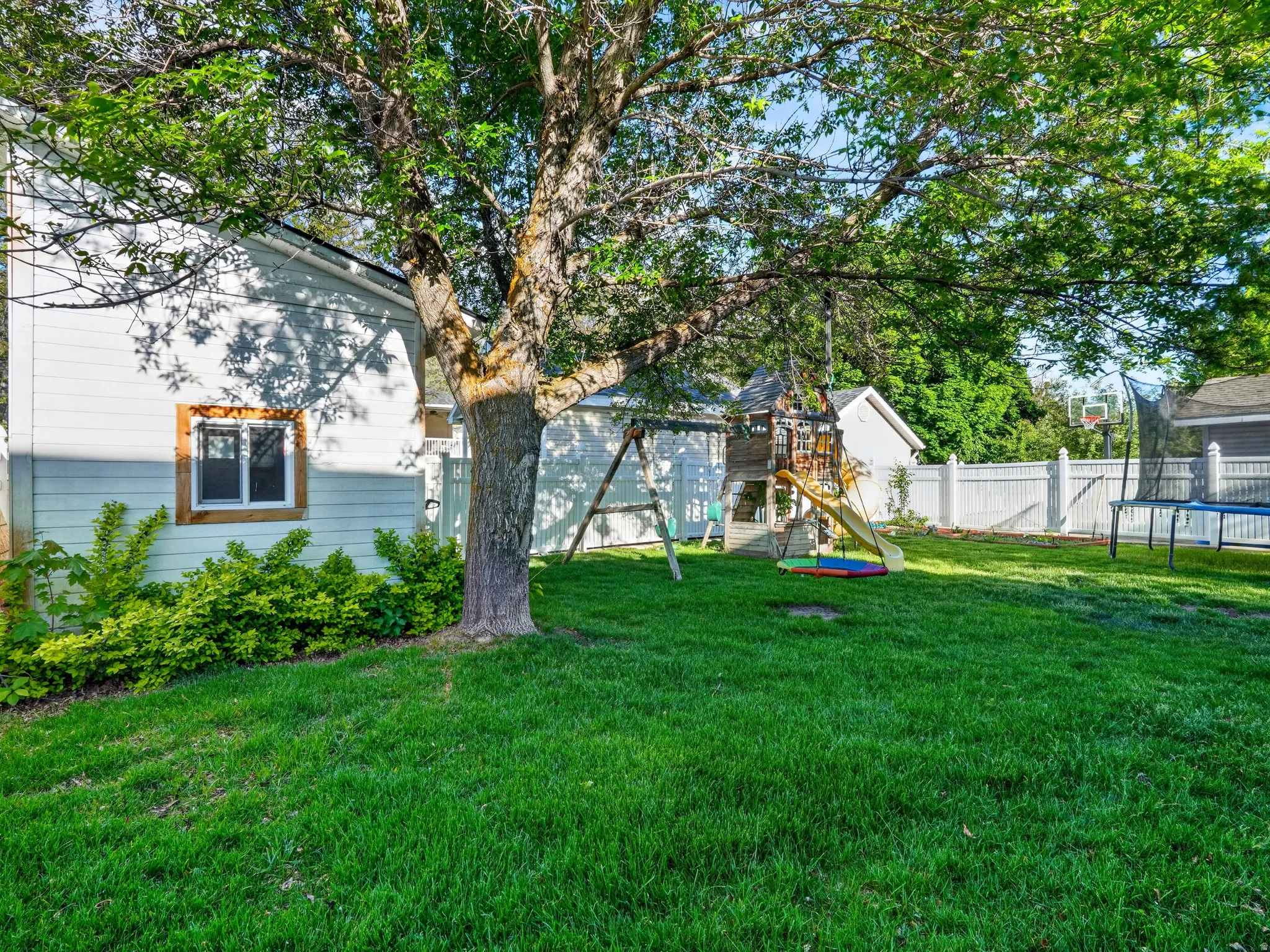 Expansive lawn area featuring a mature shade tree