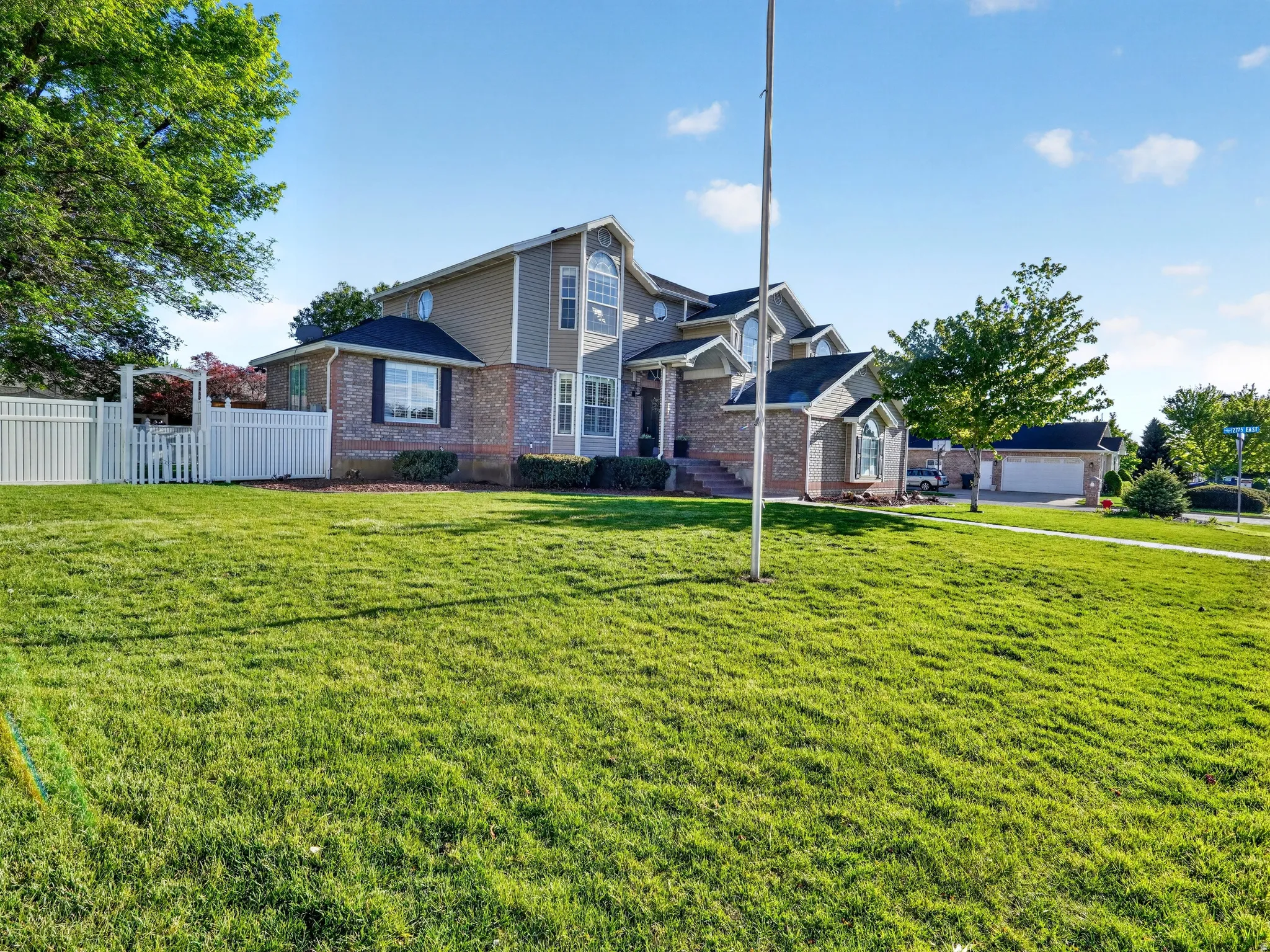 Multi-level residence featuring brick and siding exterior, bay windows, and a two-car garage