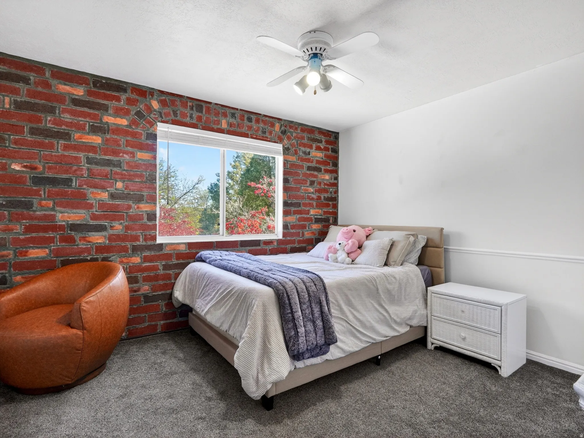 Exposed brick accent wall with a window offering exterior scenery