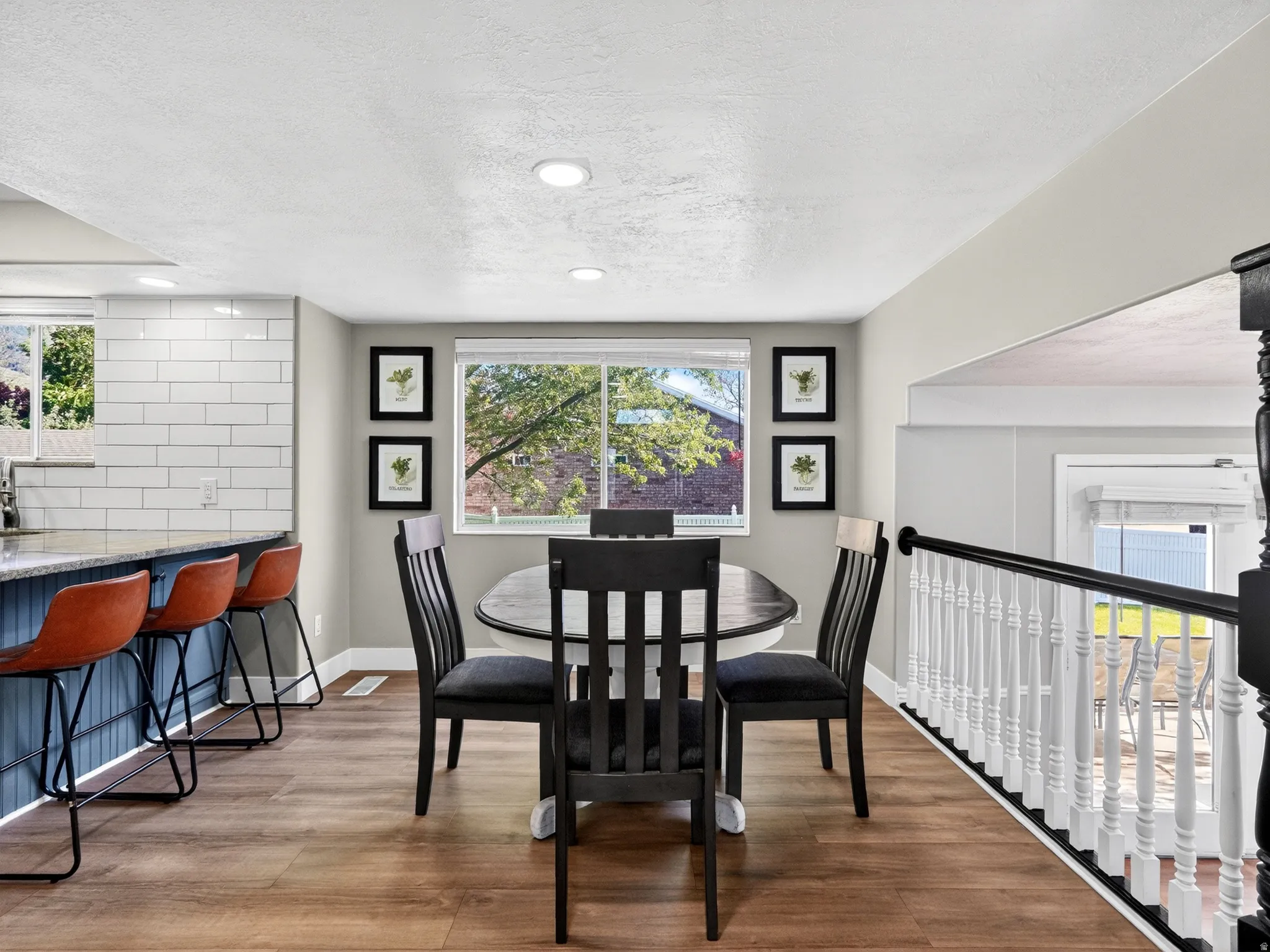 Dining area featuring wood-finish flooring, a large window, and recessed lighting