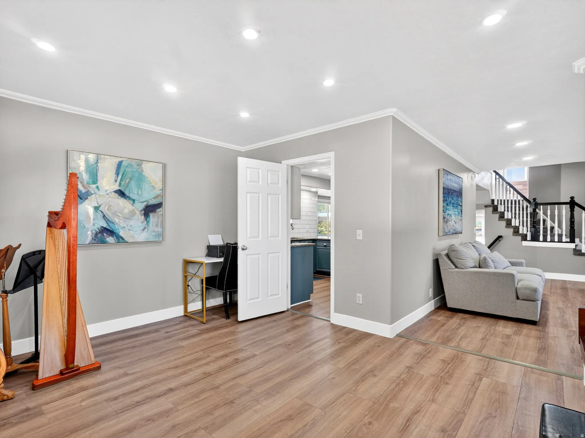 Spacious living area featuring wood-finish flooring, recessed lighting, and crown molding