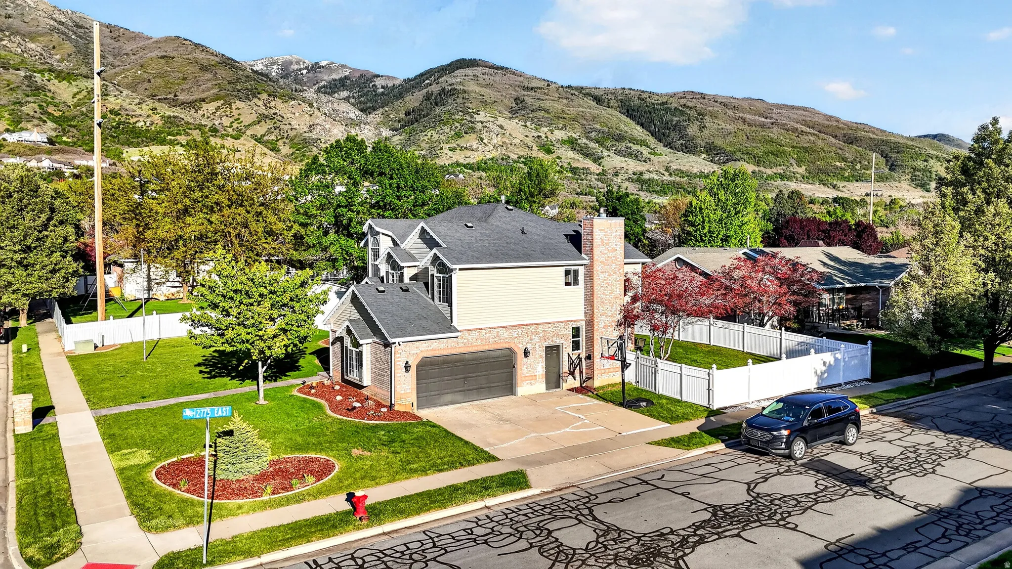 Two-story residence featuring brick and siding exterior, an attached garage, and prominent gabled rooflines