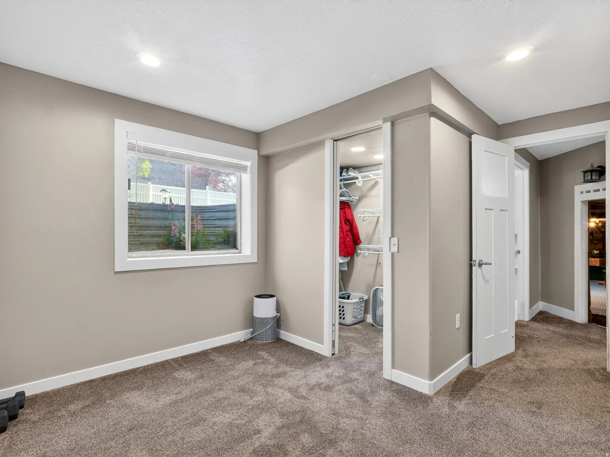 Carpeted room featuring a white-trimmed window, recessed lighting, a sliding closet door, and a paneled interior door