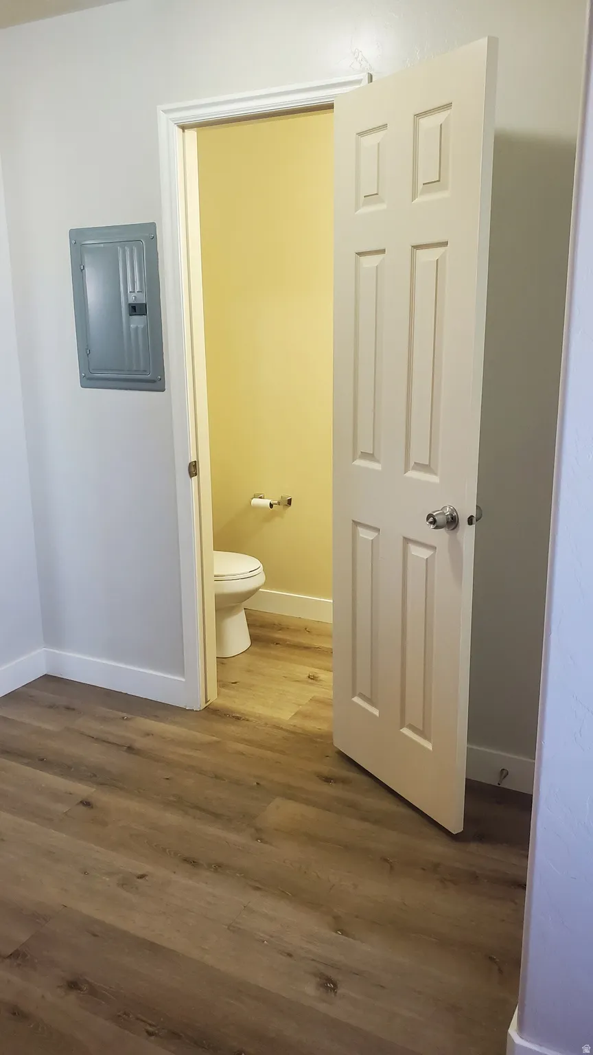 Neutral tone wood-finish flooring extends throughout the space