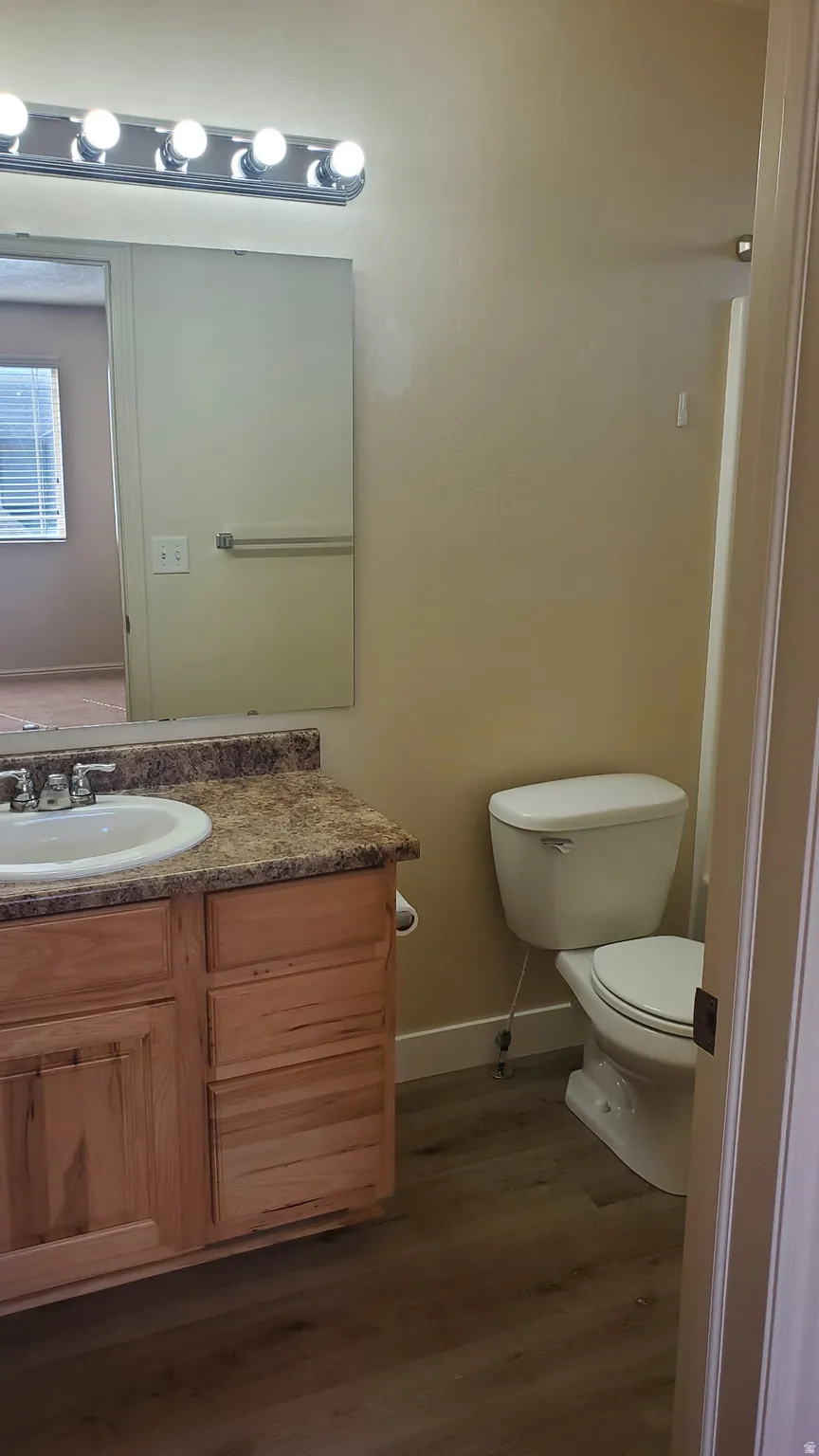 Bathroom featuring a vanity with wood cabinetry, a speckled countertop, and an integrated sink with chrome fixtures