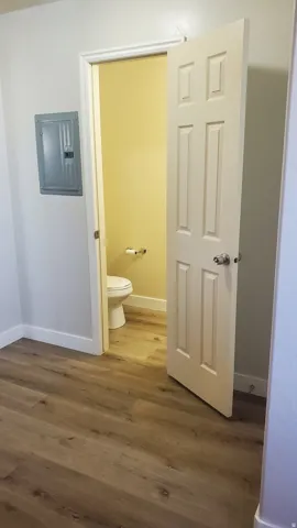Neutral tone wood-finish flooring extends throughout the space