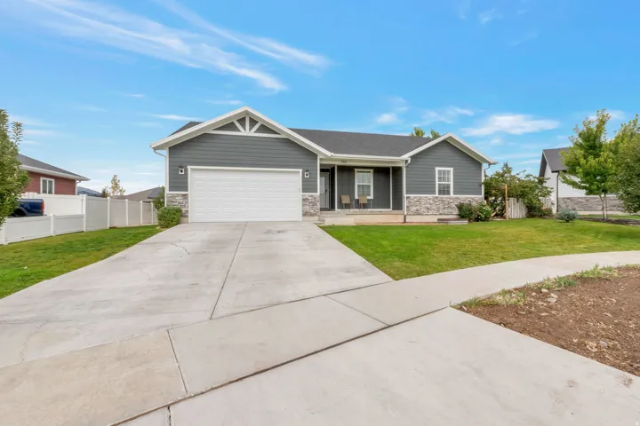 Ranch-style exterior with dark gray siding and stone veneer accents