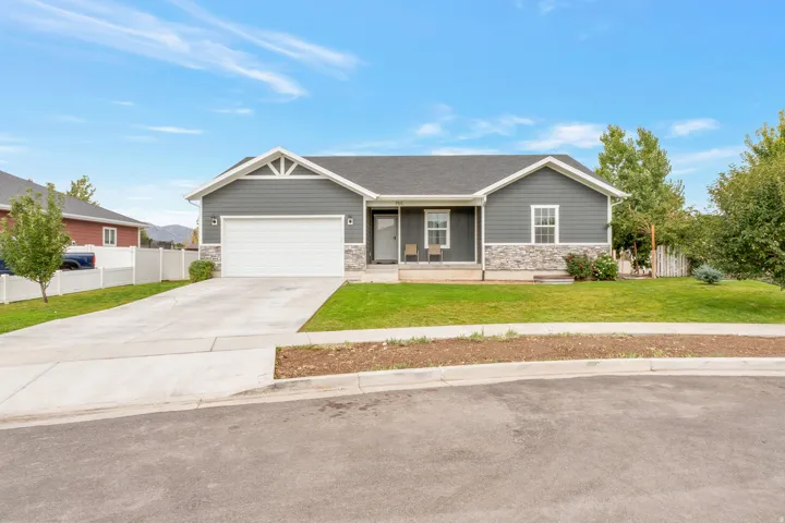 Ranch-style exterior with gray siding and stone veneer accents
