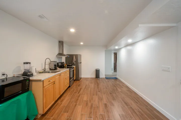 Full kitchen with stainless steel appliances, wood cabinetry, and a light-toned countertop