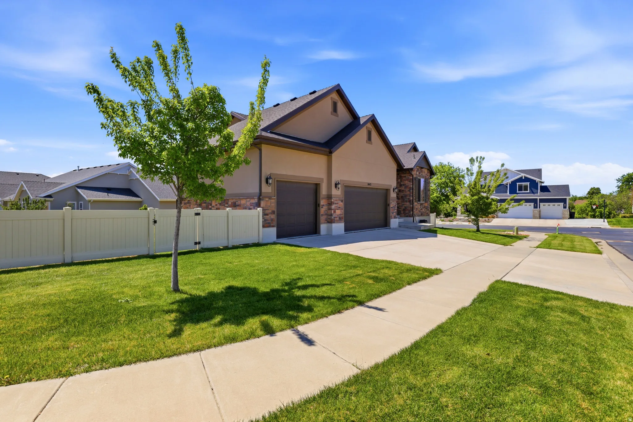 Residence featuring a two-car garage, stucco and stone-veneer exterior, and a concrete driveway
