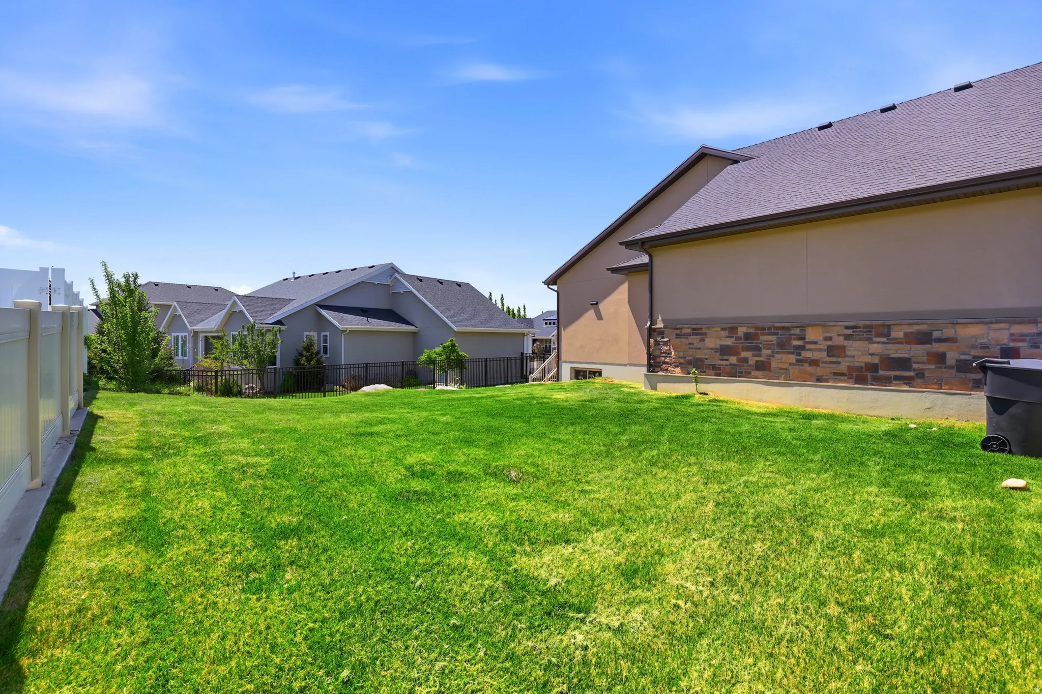 Expansive green lawn with a vinyl privacy fence