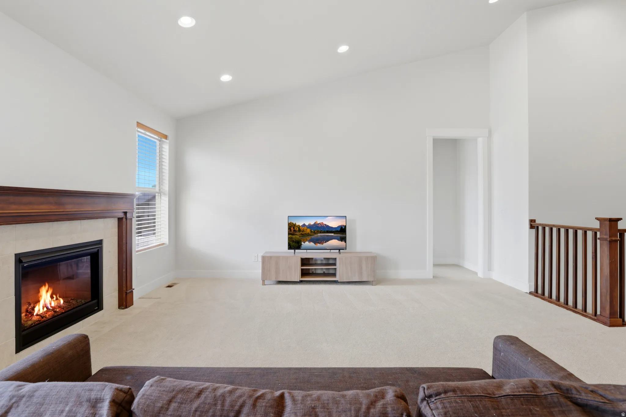 Spacious living area featuring a vaulted ceiling and recessed lighting