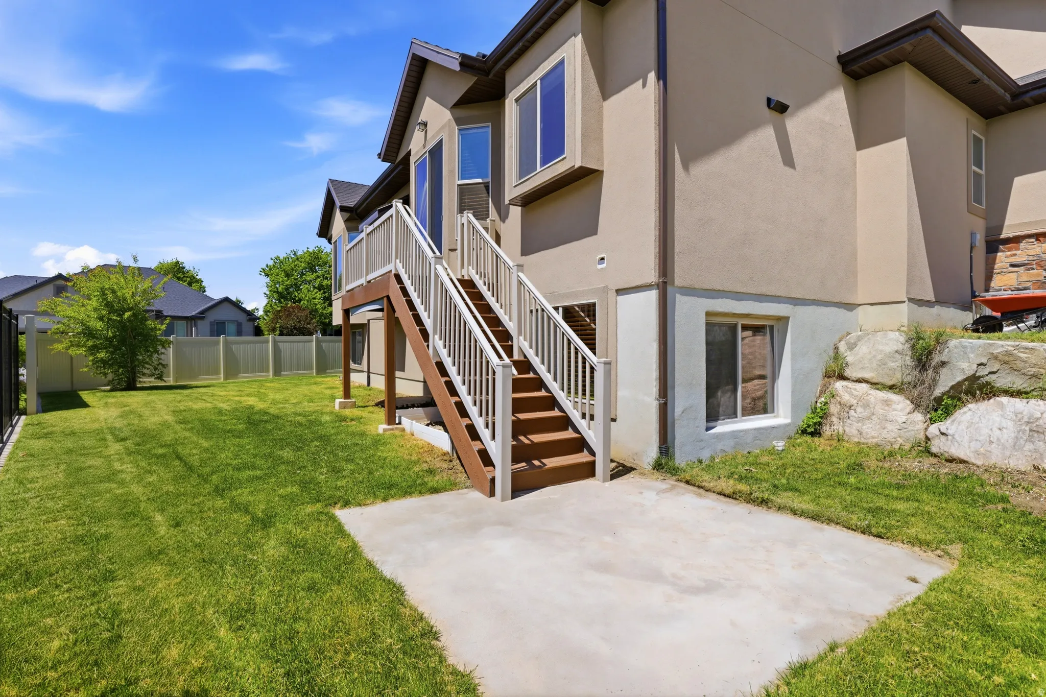 Spacious backyard featuring a manicured lawn, full fencing, and mature trees
