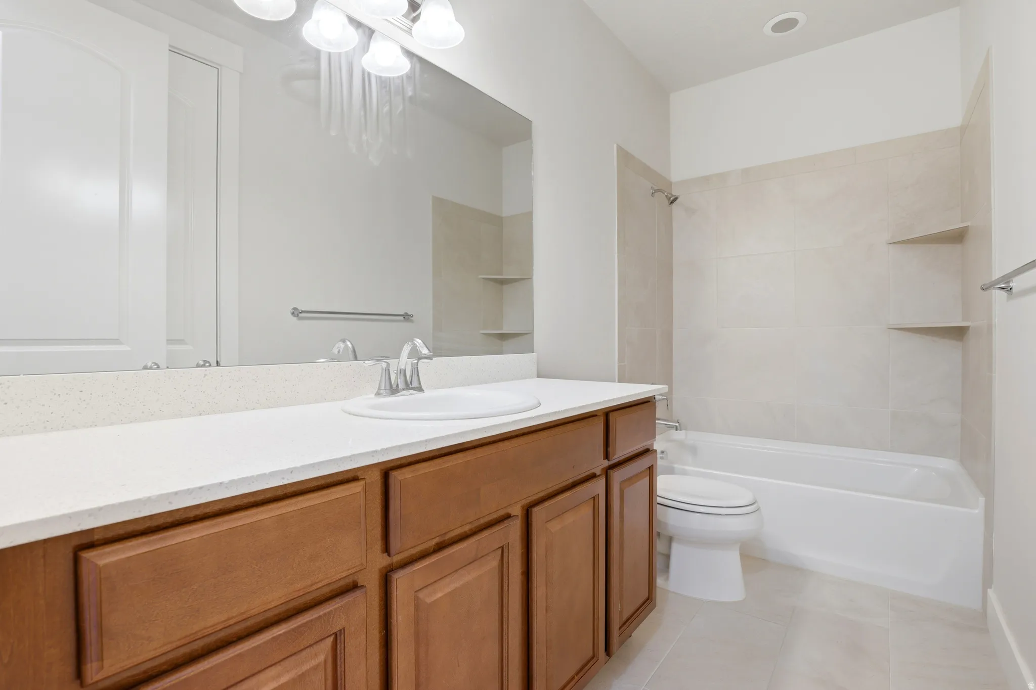 Bathroom vanity featuring a light-colored countertop, an undermount sink, and a chrome faucet