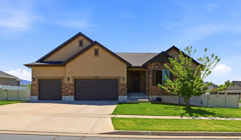 Ranch-style residence featuring a stucco and stone veneer facade