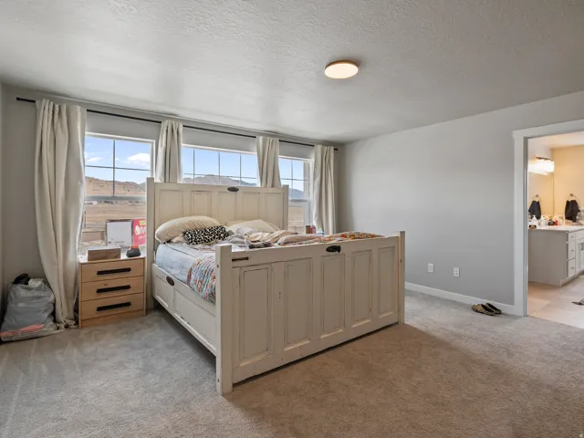 Spacious room featuring multiple large windows with mountain scenery, neutral wall tones, and plush carpeting