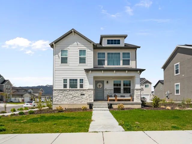 Contemporary two-story residence featuring a combination of light-colored siding and stone veneer