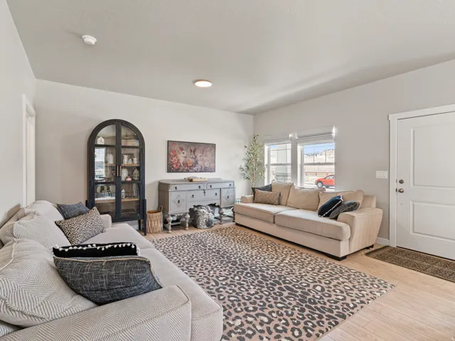 Open-concept living space featuring light wood-finish flooring, neutral wall tones, and recessed lighting