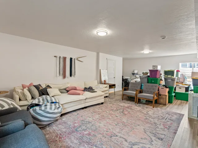 Spacious room featuring light-toned walls, recessed lighting, and wood-finish flooring