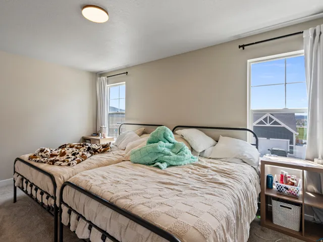 Bright room featuring two large windows with white trim and black curtain rods