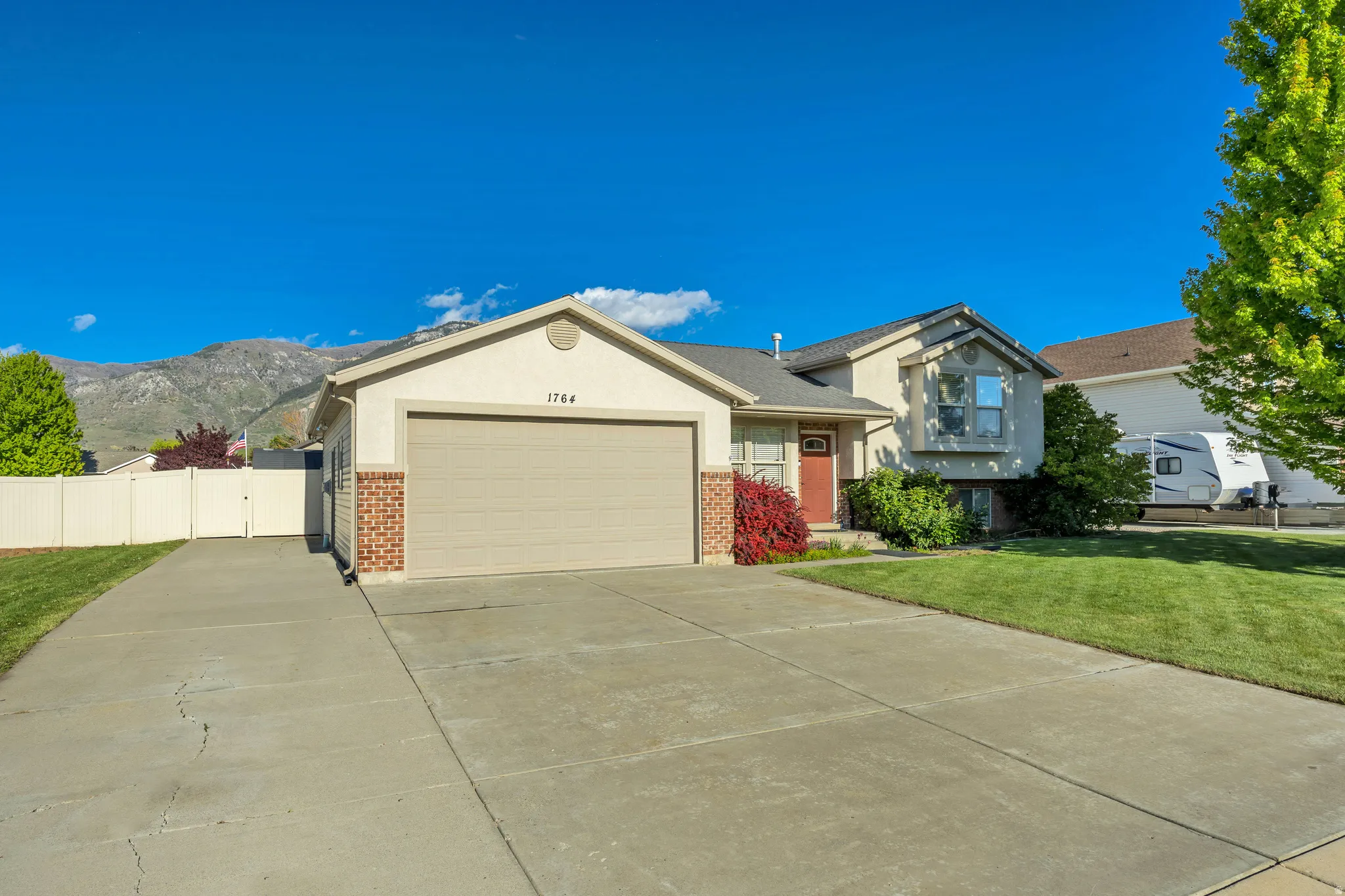 Stucco exterior with brick accents and an attached two-car garage