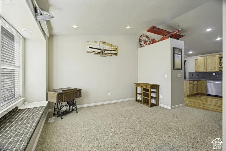 Recessed lighting illuminates the carpeted living area with a built-in window seat