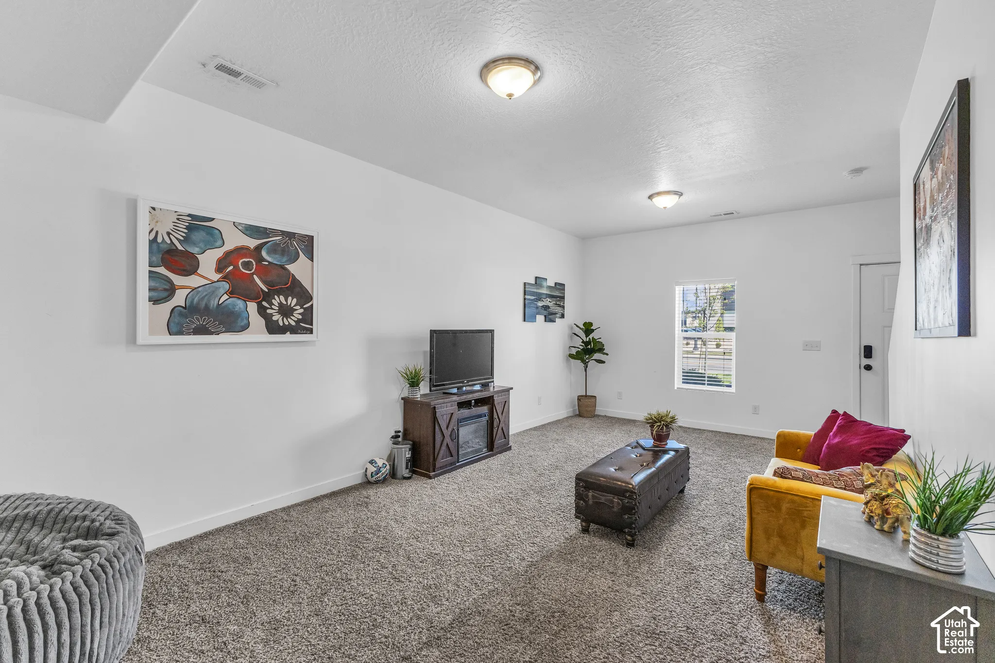 Carpeted living space featuring white walls and recessed lighting