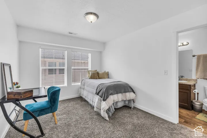 Bedroom featuring two windows with blinds, gray carpet flooring, and a flush mount ceiling light