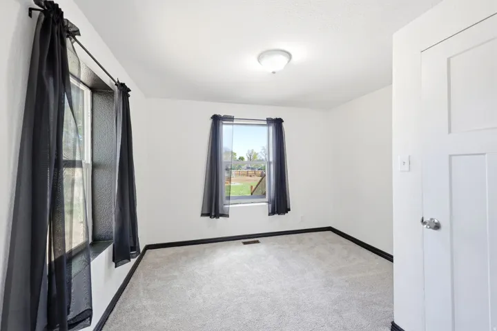 Unfurnished room featuring light colored carpet and baseboards