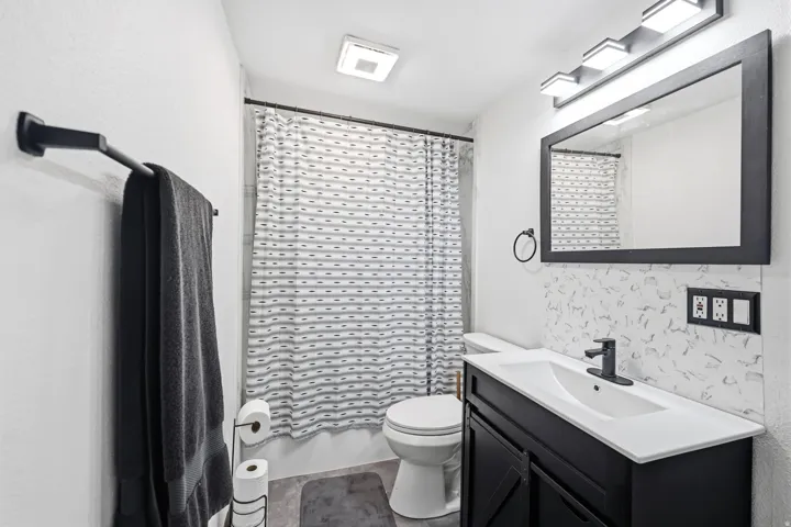 Full bath featuring vanity and shower / bath combo with shower curtain