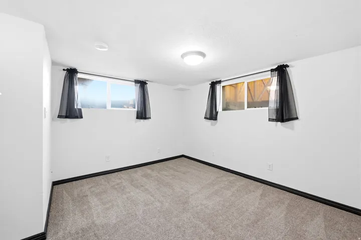 Carpeted spare room featuring baseboards