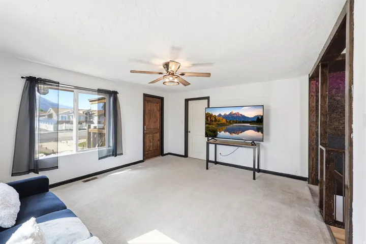 Sitting room with light carpet, ceiling fan, and a textured ceiling
