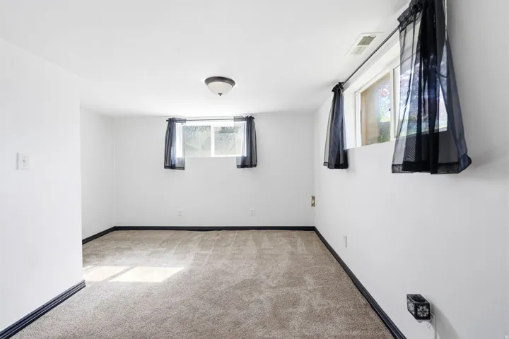 Empty room with light carpet and baseboards