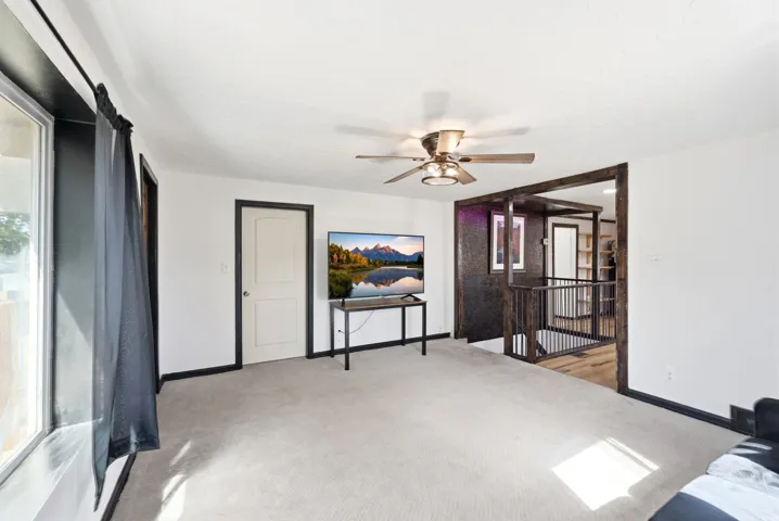 Bedroom with light colored carpet and ceiling fan