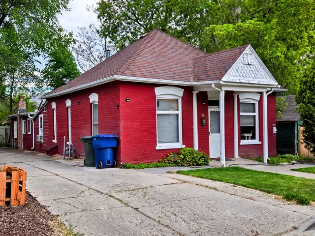 Red brick exterior featuring white trim and a gabled porch entrance