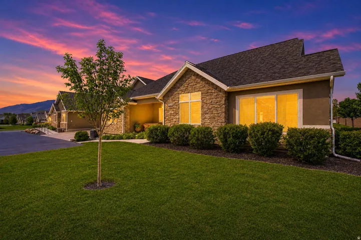 Ranch-style house featuring a front lawn, stone siding, stucco siding, and roof with shingles