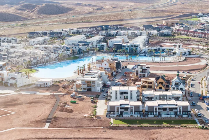 Community featuring a large recreational lagoon with surrounding residential buildings and undeveloped land