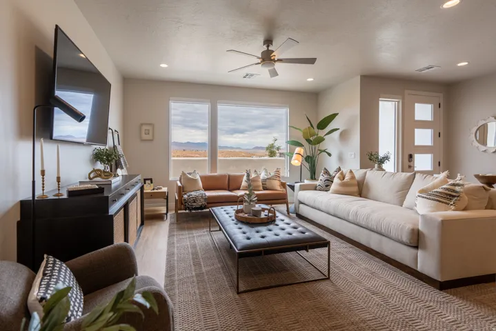 Spacious living area featuring large windows, wood-finish flooring, recessed lighting, and a ceiling fan