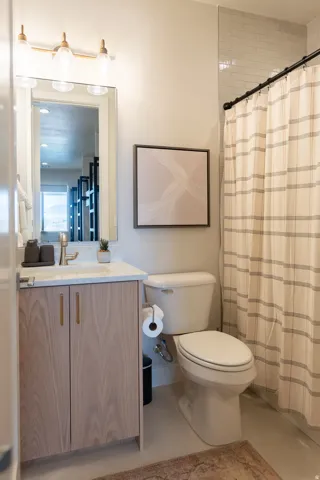 Bathroom featuring a single vanity with wood-finish cabinetry, a white countertop, and a brushed nickel faucet