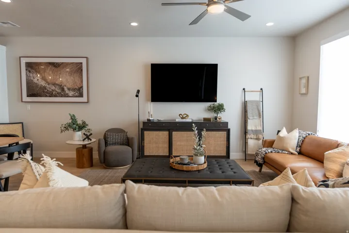 Open-concept living space featuring wood-finish flooring, recessed lighting, and a ceiling fan with integrated lighting