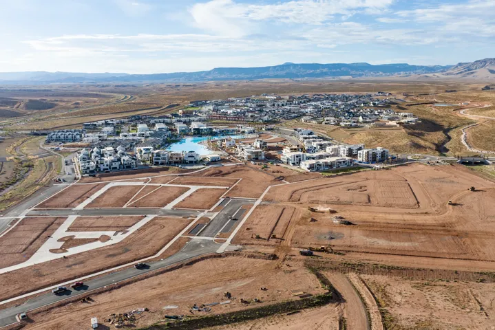 Expansive aerial overview showcasing a developing community with established residences and new construction plots