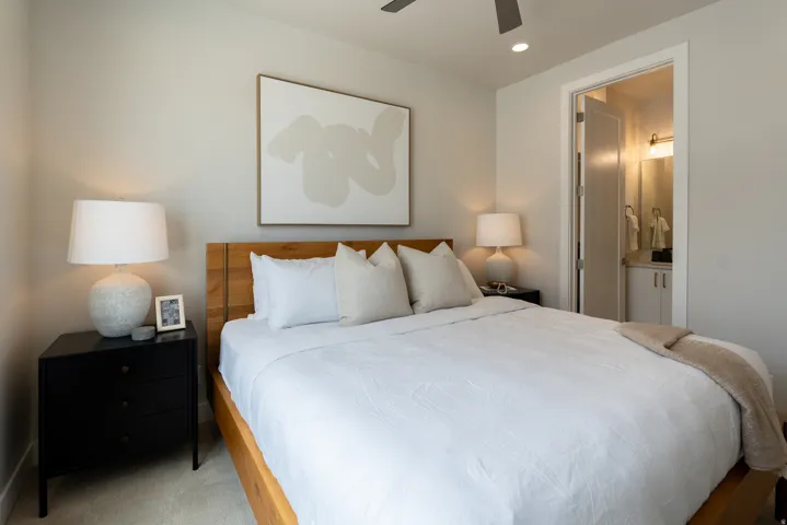 Bedroom featuring a wood-finish bed frame, carpeted flooring, and a ceiling fan