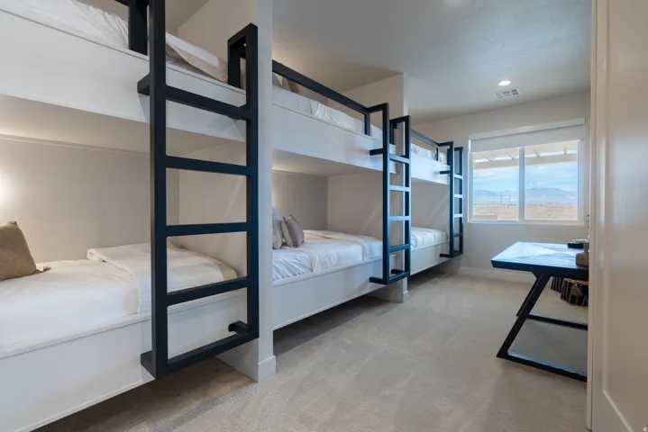 Built-in bunk beds featuring dark-toned ladders and white bed frames
