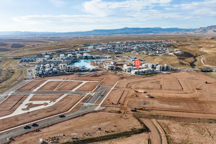 Expansive desert landscape featuring a residential development with structured road infrastructure and graded parcels