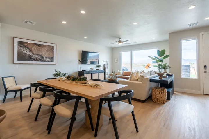 Open-concept dining and living area featuring wood-finish flooring, recessed lighting, and a ceiling fan