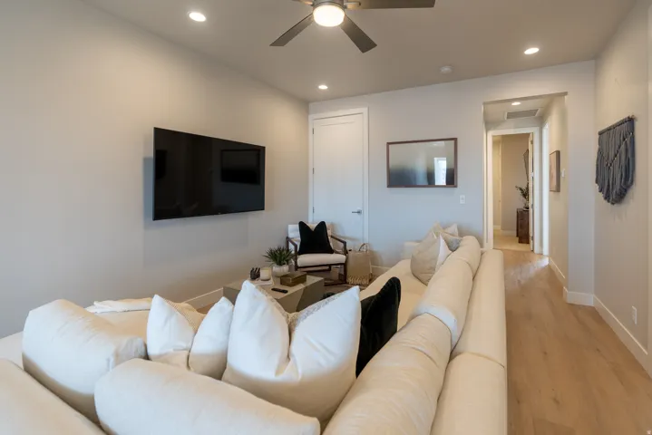 Recessed lighting illuminates the space, complemented by a ceiling fan
