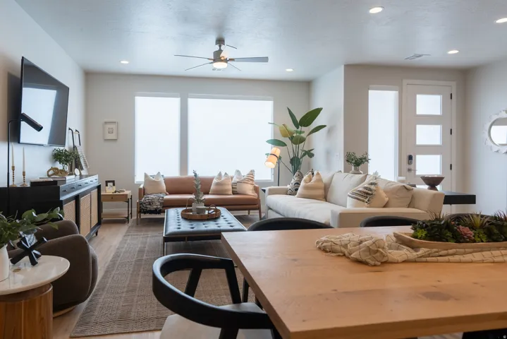 Open-concept living area featuring wood-finish flooring, recessed lighting, a ceiling fan, and large windows