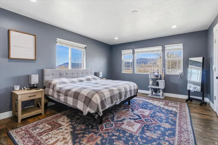 Spacious room featuring wood-finish flooring, recessed lighting, and multiple windows