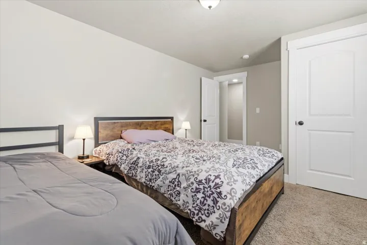 Carpeted room featuring two panel doors with black hardware, neutral wall paint, and white trim